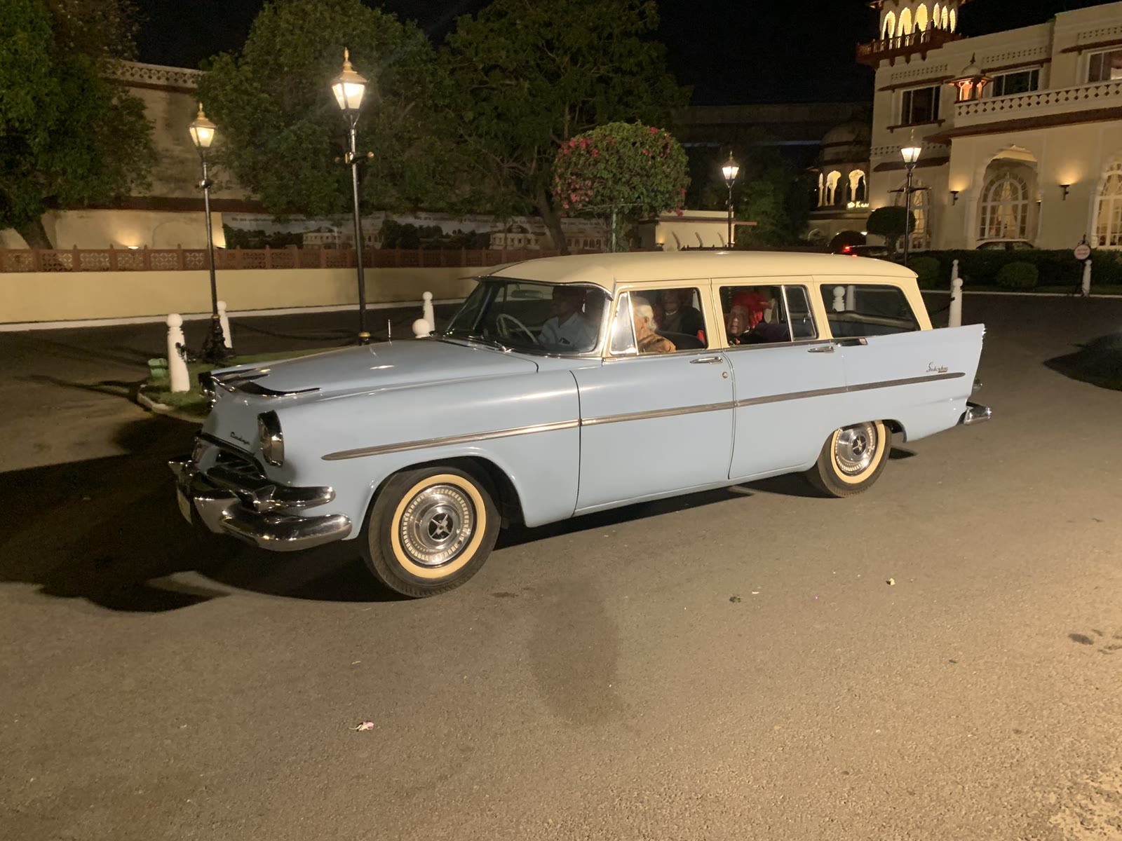 A 1956 Dodge Custom Royal Suburban in the forecourt of a Jaipur palace hotel at night