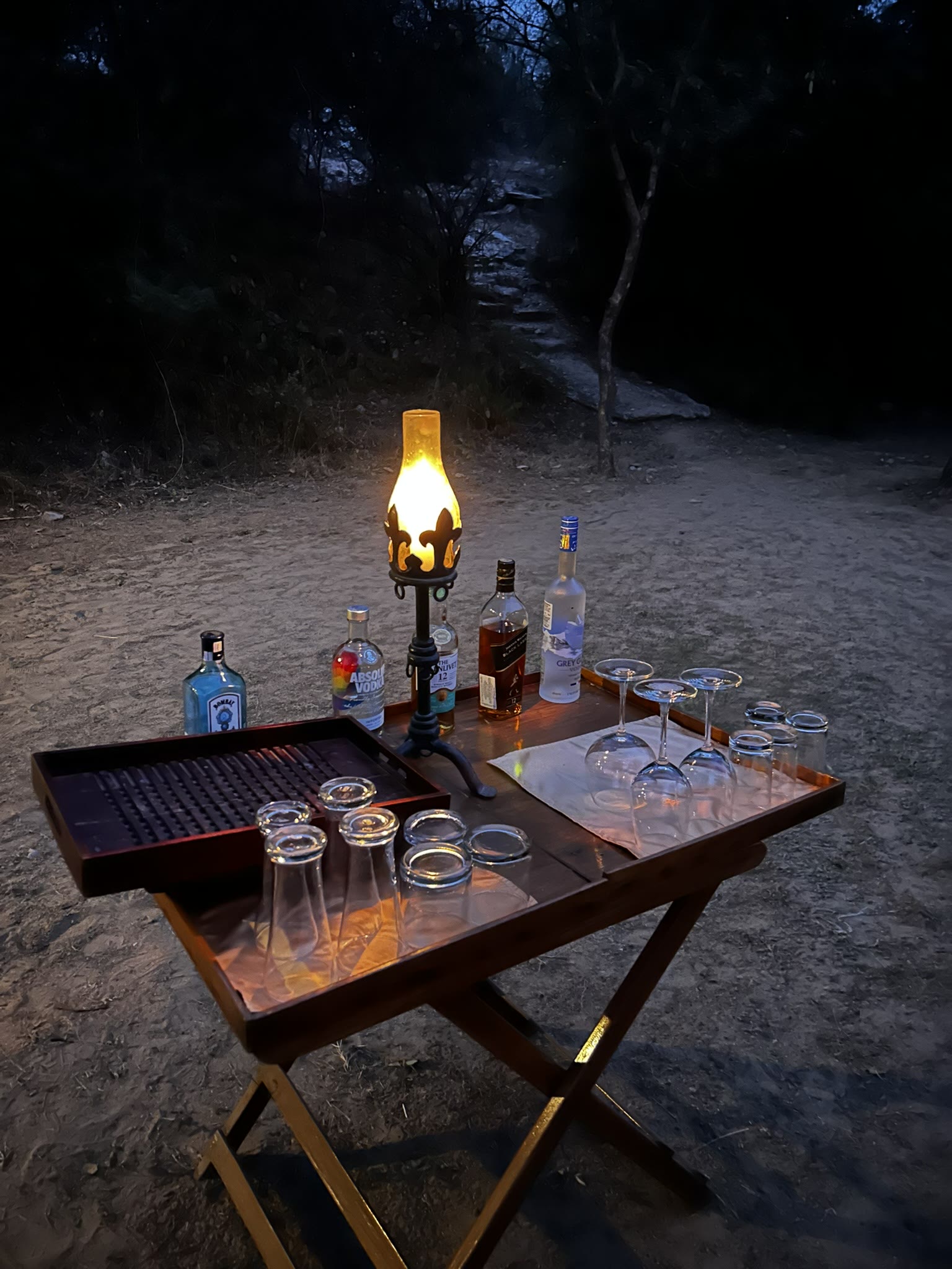 A lantern-lit bar set up in the forest at Pench Tree Lodge