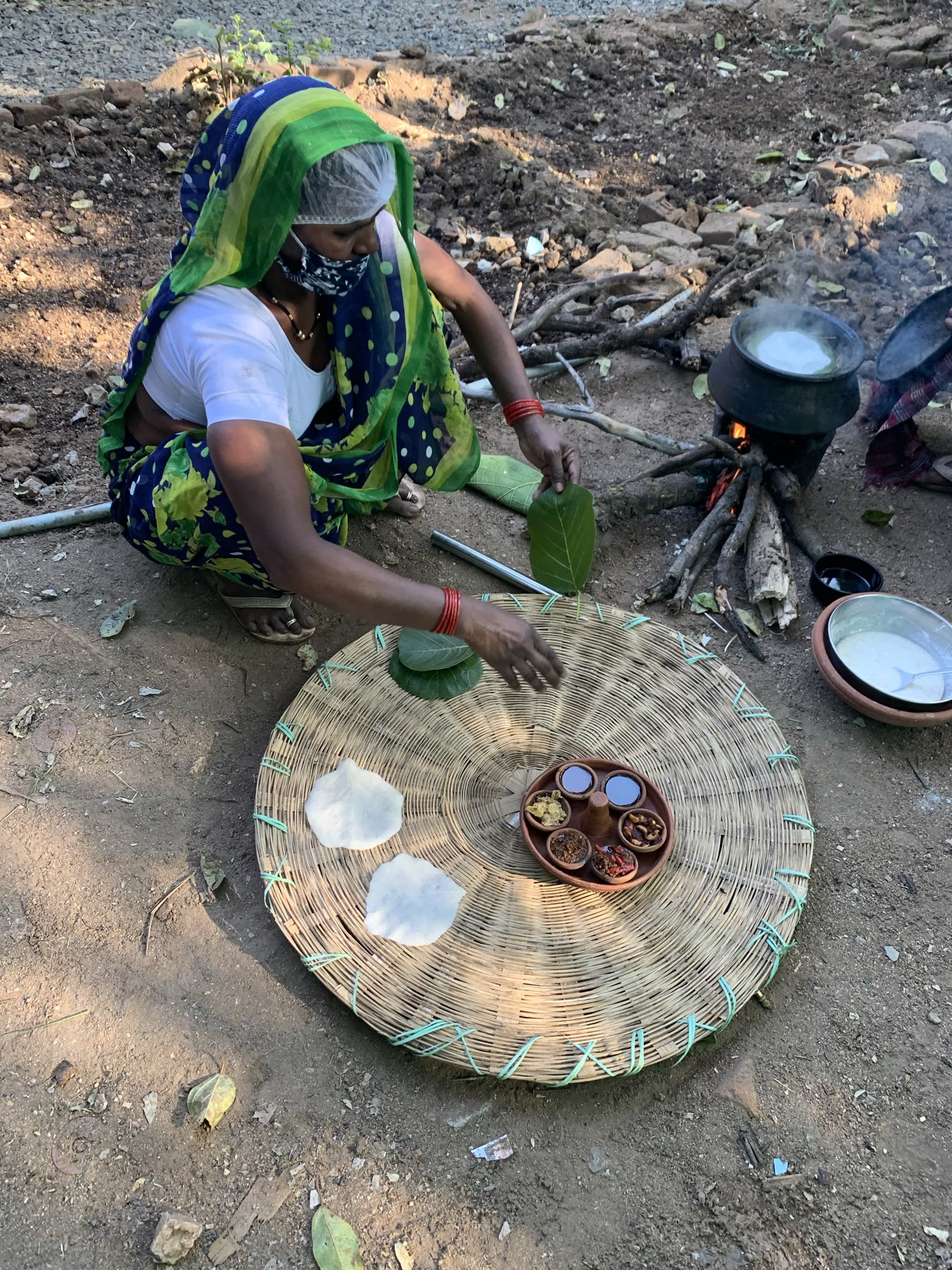 A village cook making bread over a wood fire during a cooking workshop near Pench