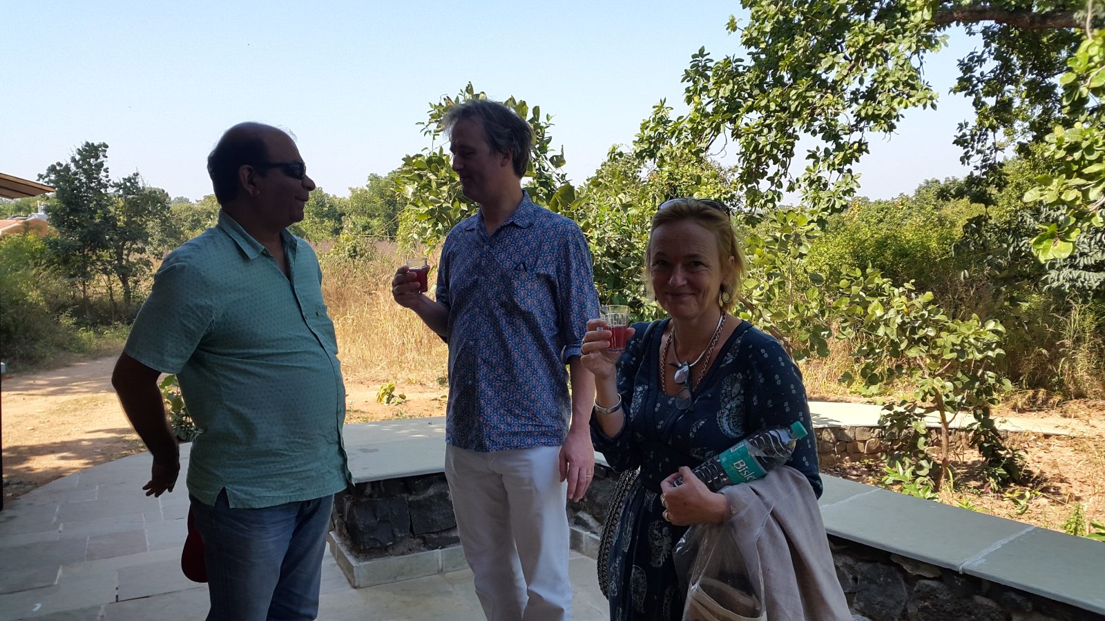 Guests sharing a welcome drink on the lodge terrace at the edge of the forest in Pench