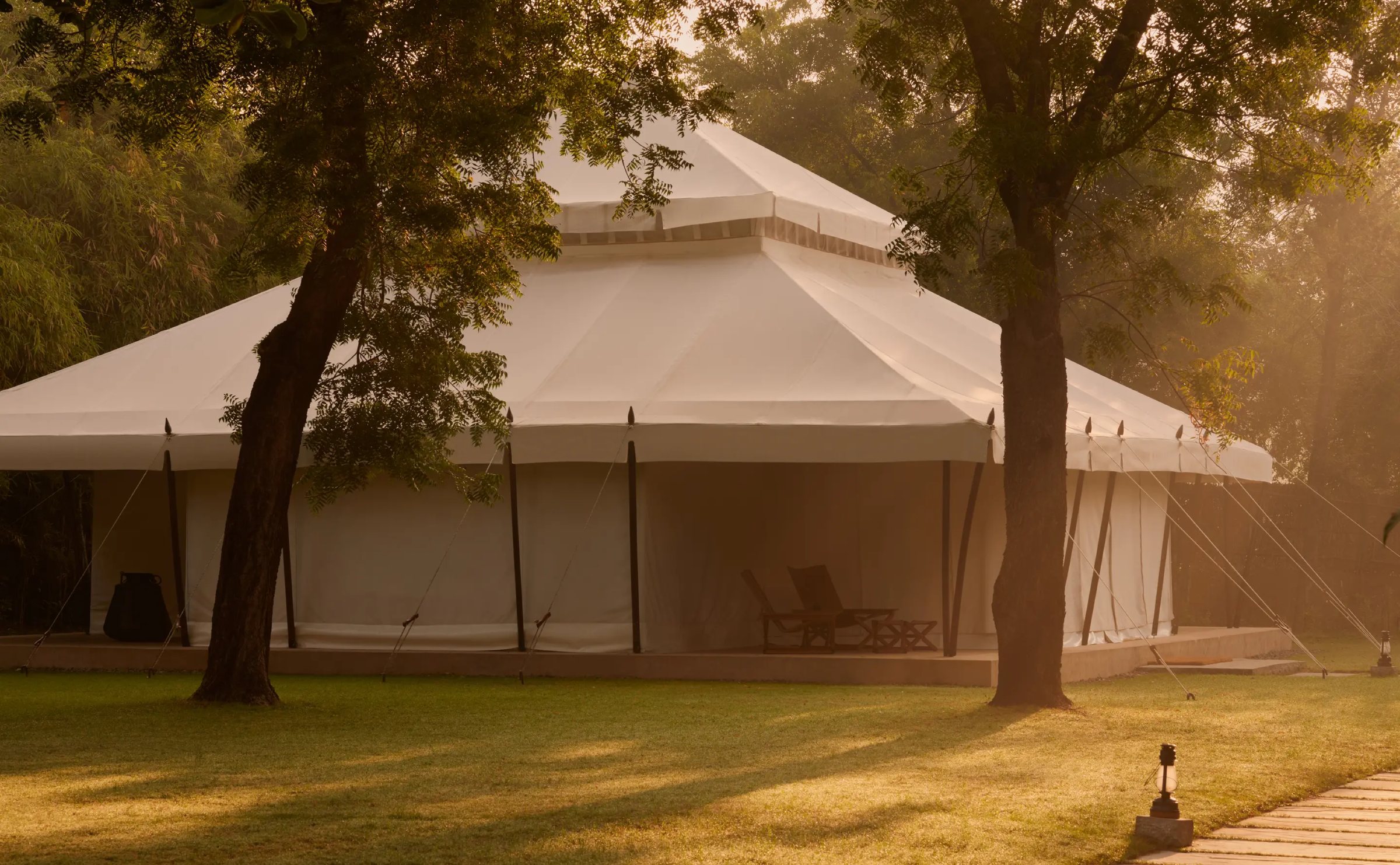 A Mughal-inspired canvas tent among trees at Aman-i-Khás in soft morning light