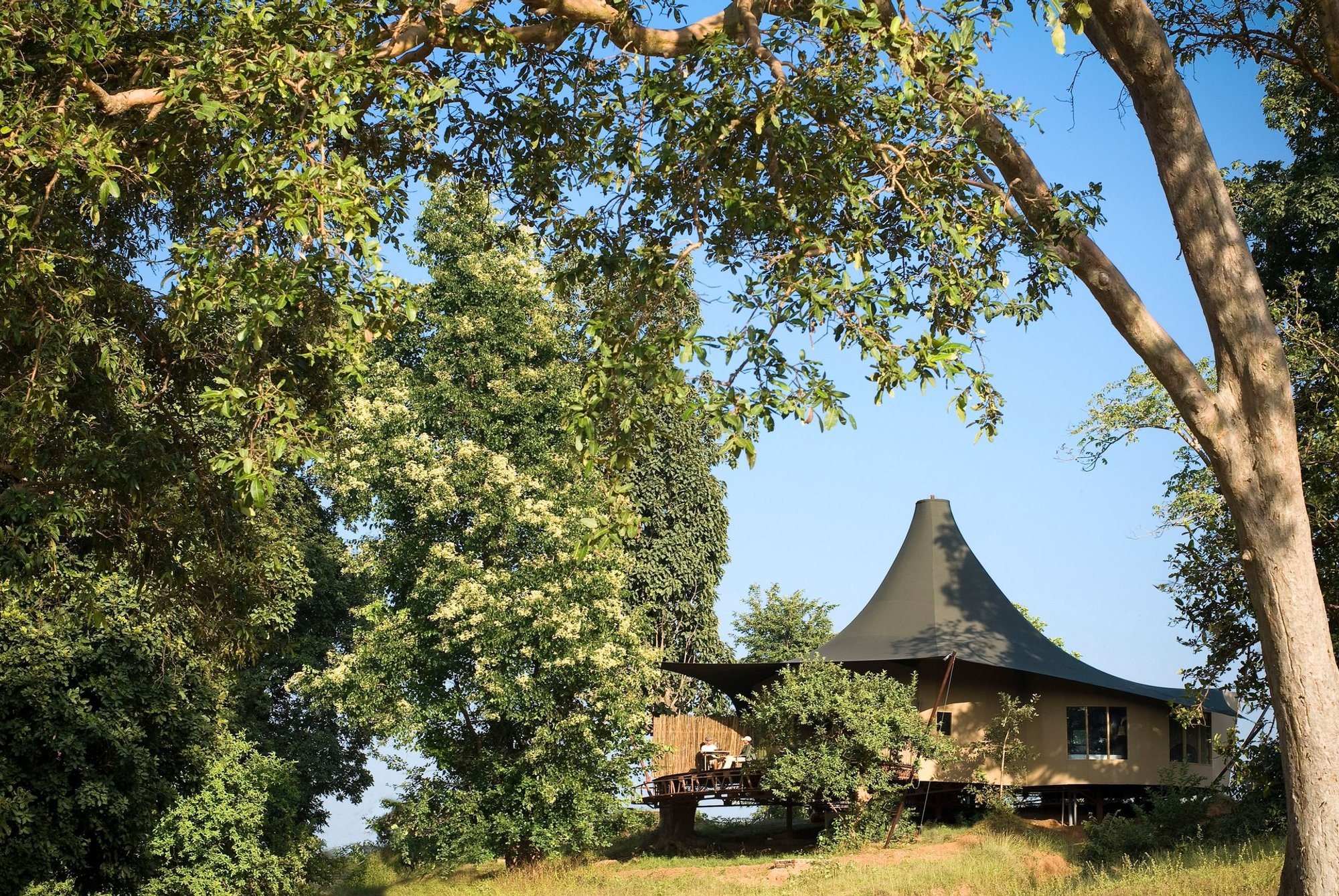 A tent with a peaked roof among trees at Banjaar Tola