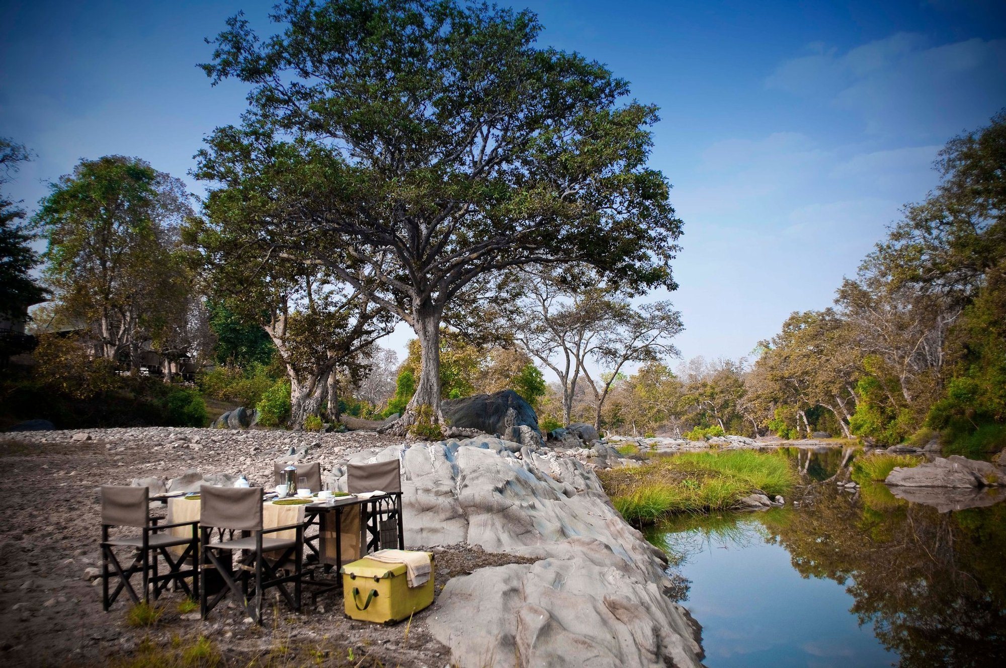 A table laid on the rocks beside the river at Banjaar Tola