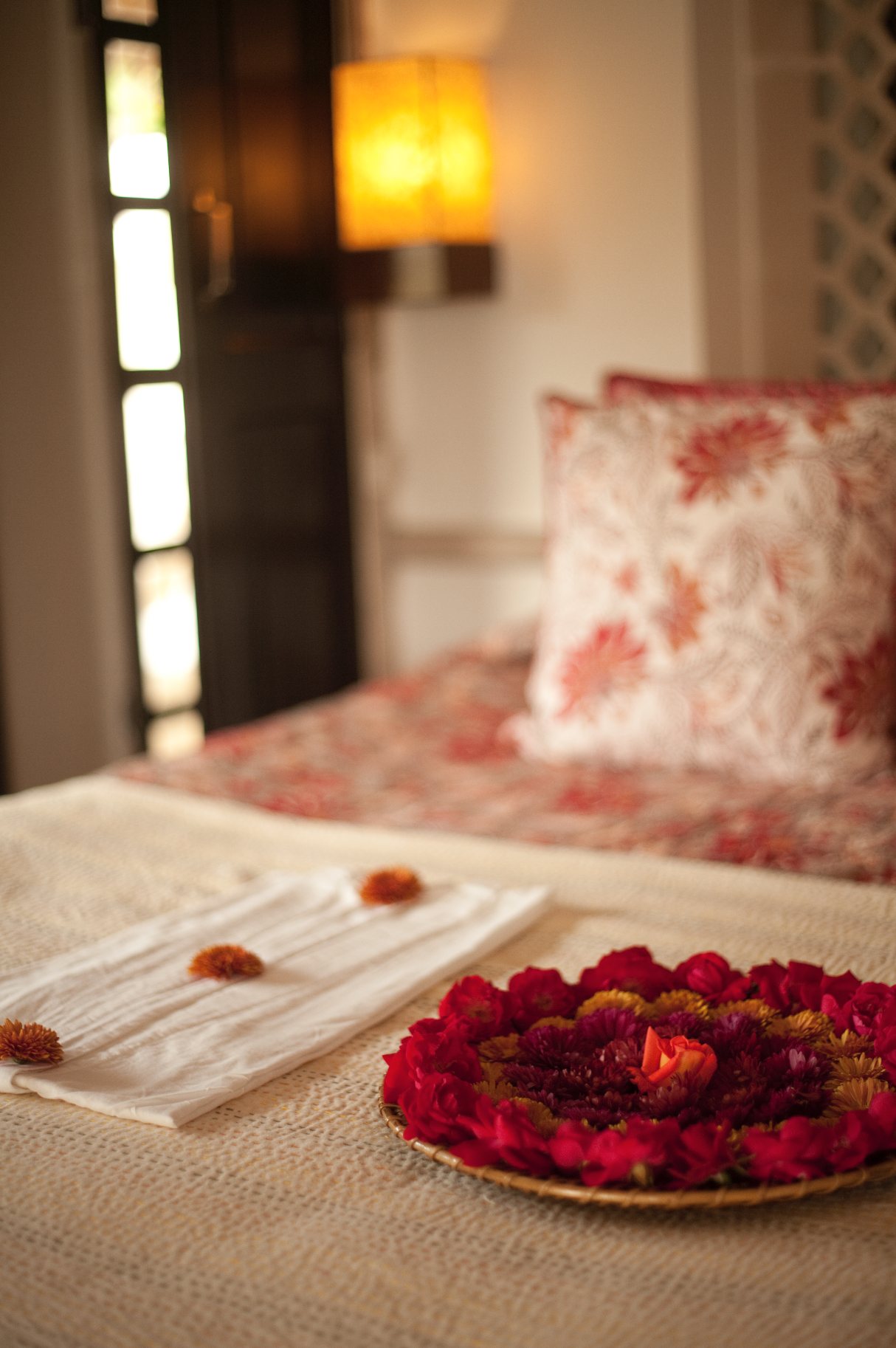 Bedside at Khem Vilas, with a block-printed cushion and a tray of rose petals