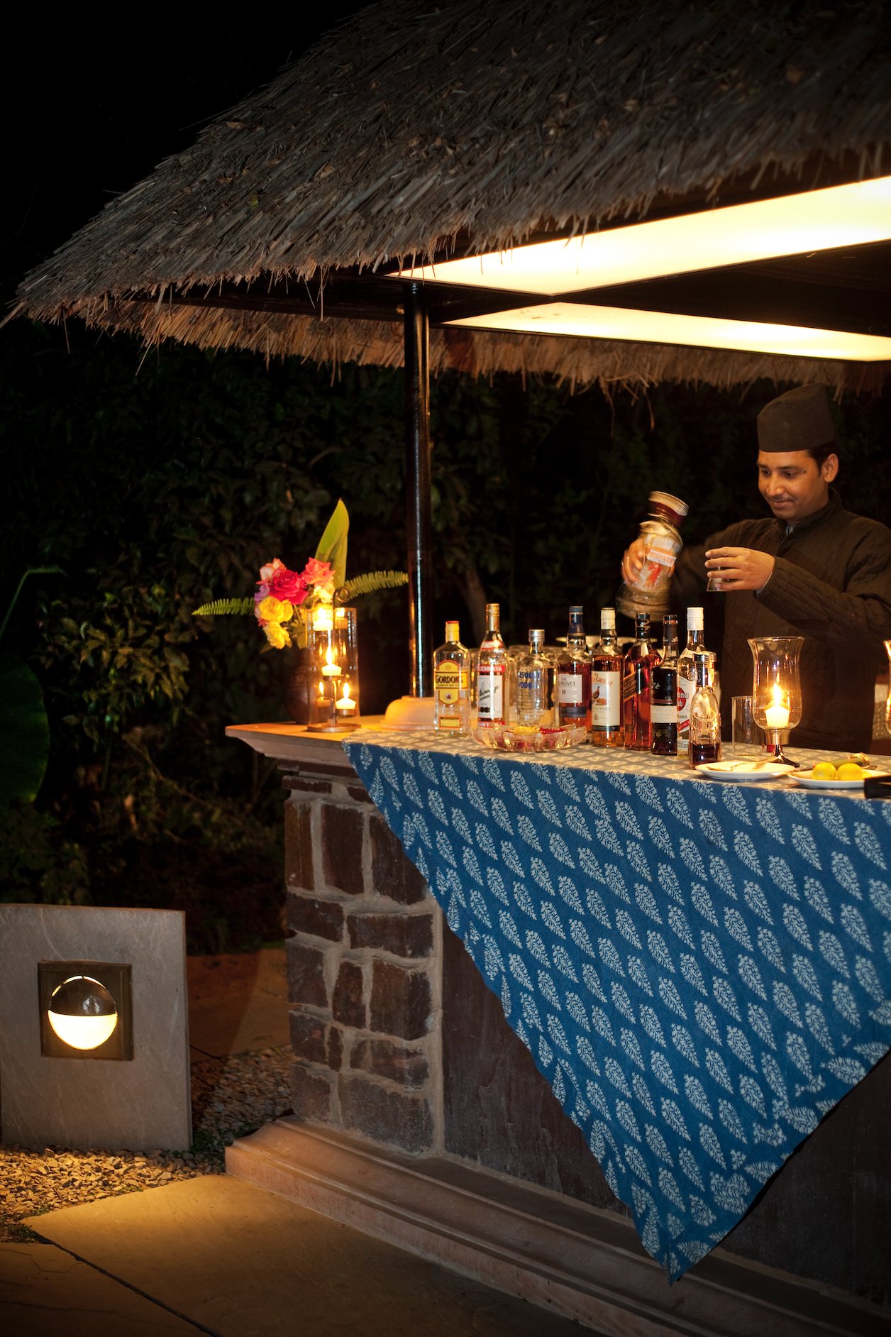 A lantern-lit bar under a thatched roof at Khem Vilas