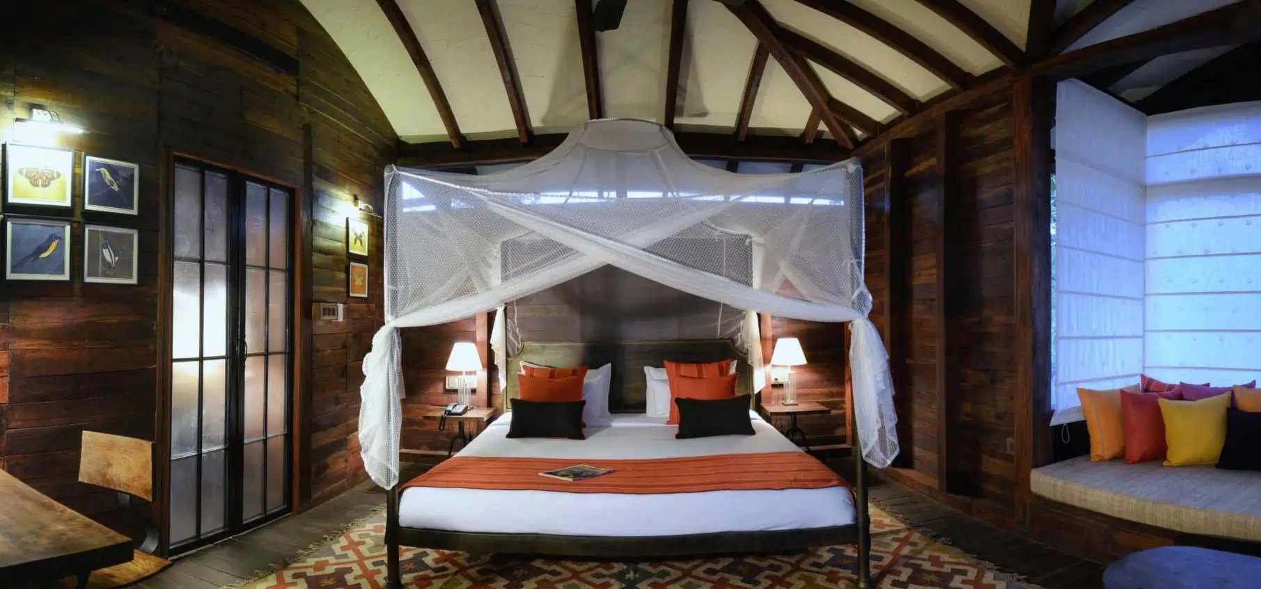 A treehouse bedroom at Pench Tree Lodge with a netted four-poster bed