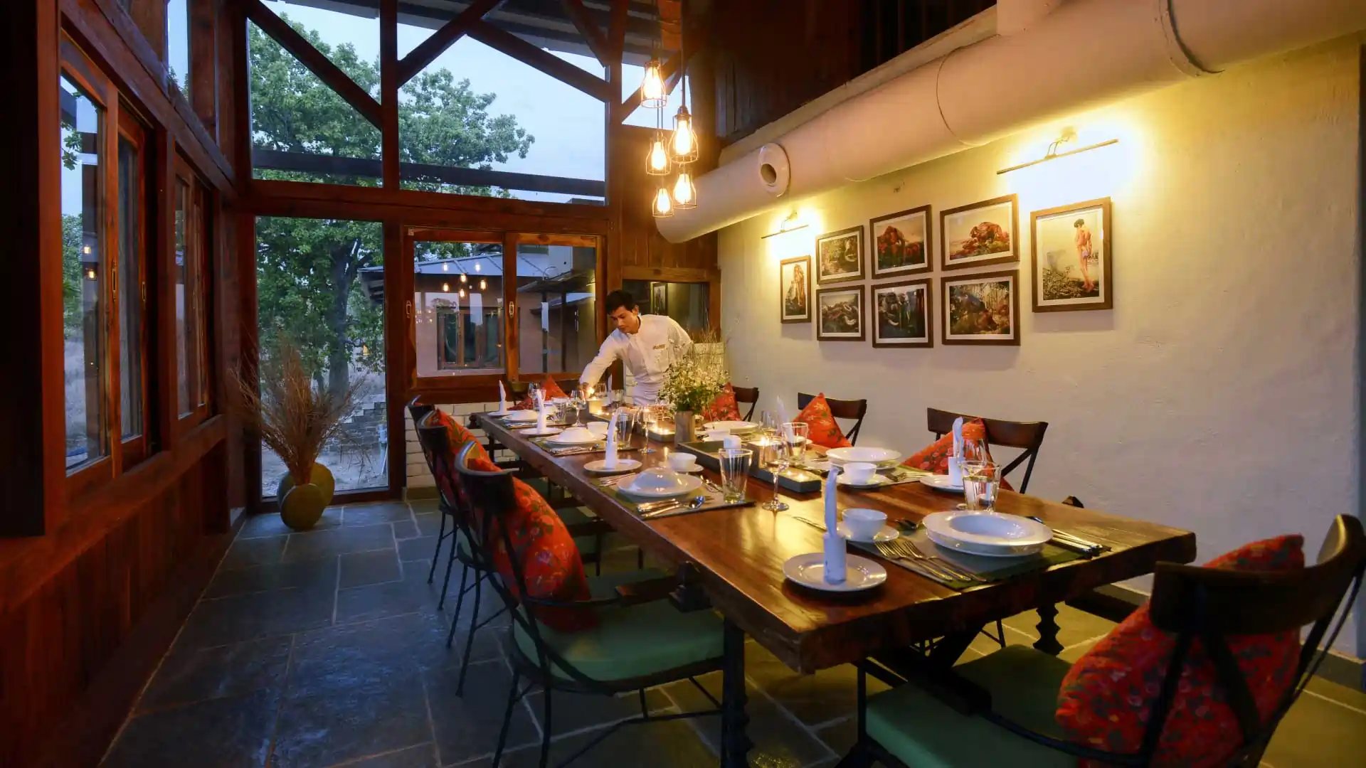 The dining room at Pench Tree Lodge, with a long table laid for dinner