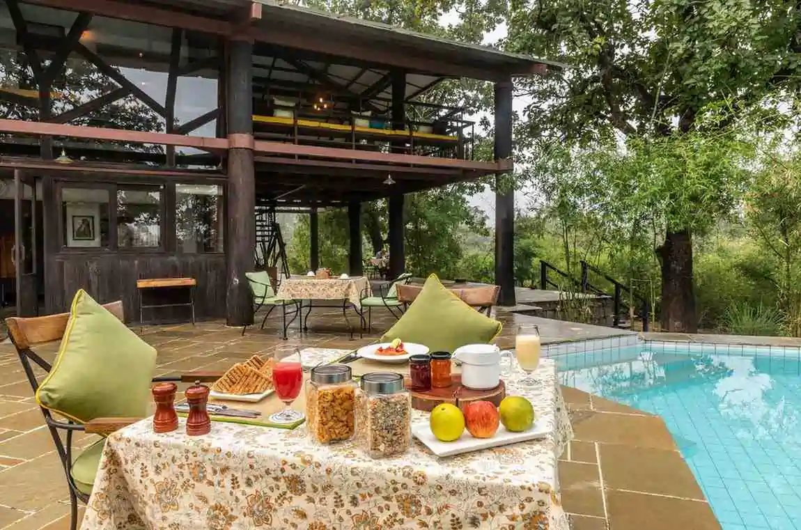 Breakfast laid by the pool at Pench Tree Lodge