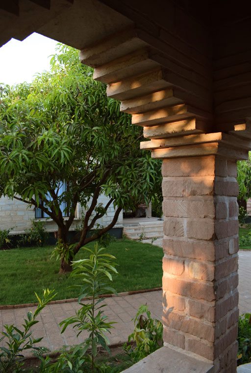 A stone archway looking onto mango trees at Postcard Gir