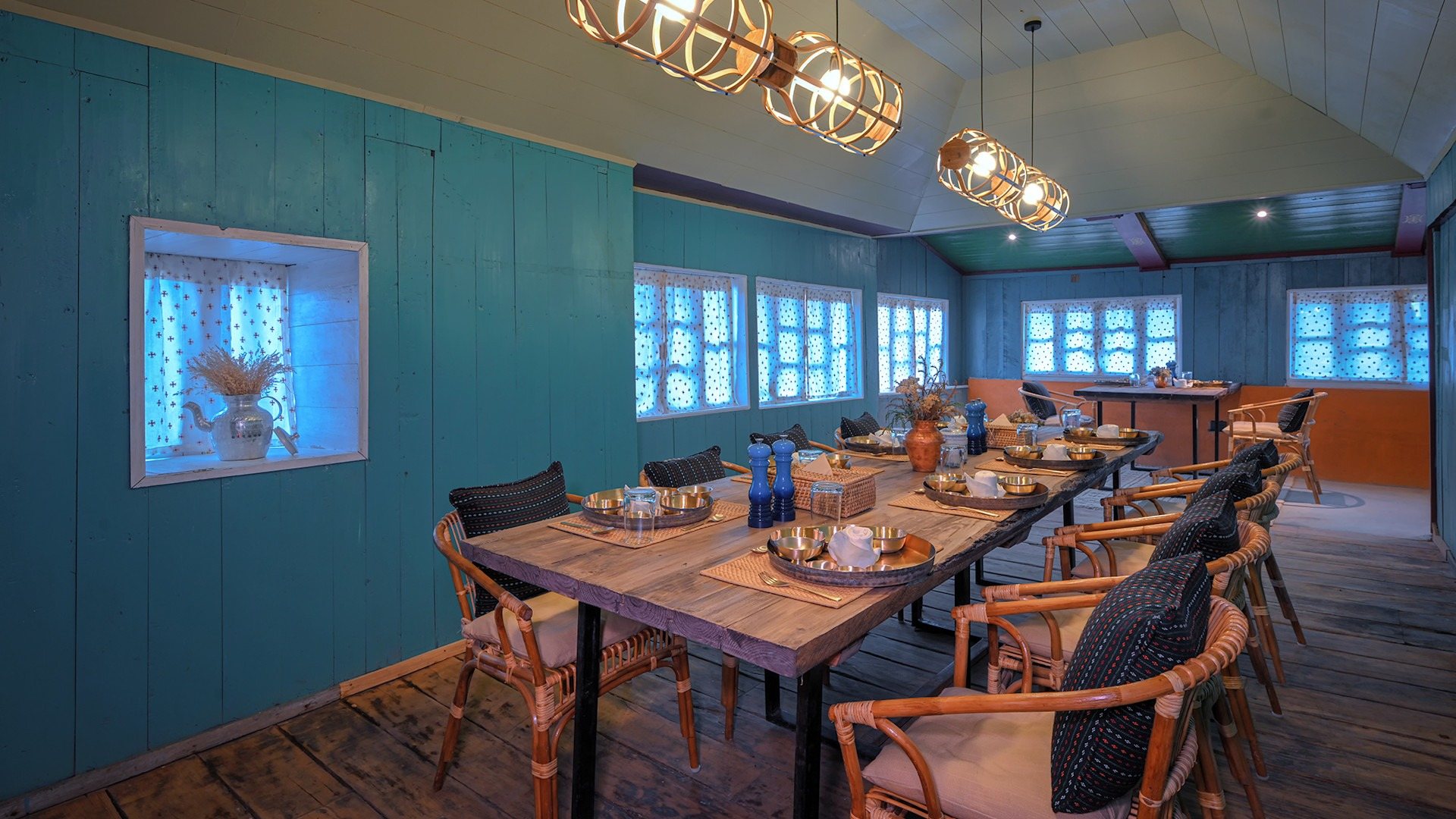 The dining room at Red Panda Outpost, with teal walls and a long wooden table