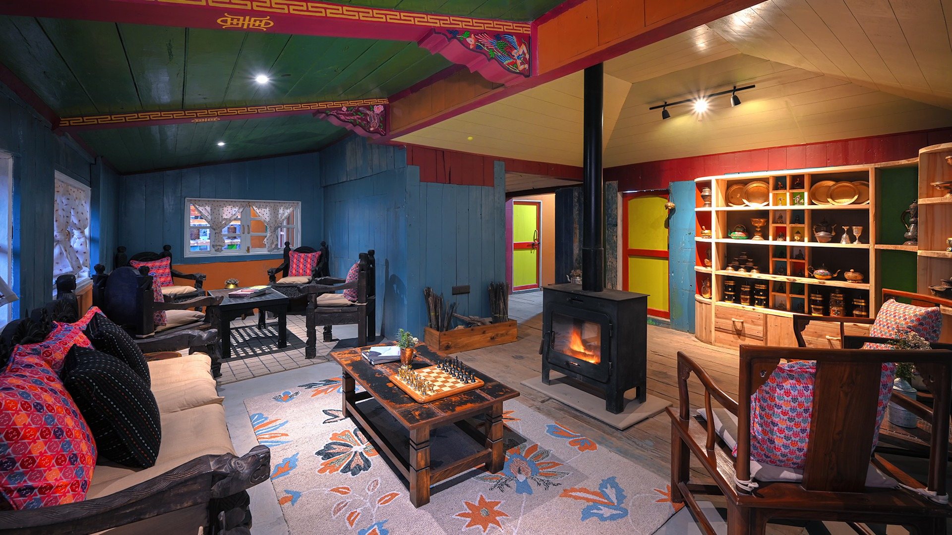 The lounge at Red Panda Outpost, with a wood-burning stove and patterned rugs