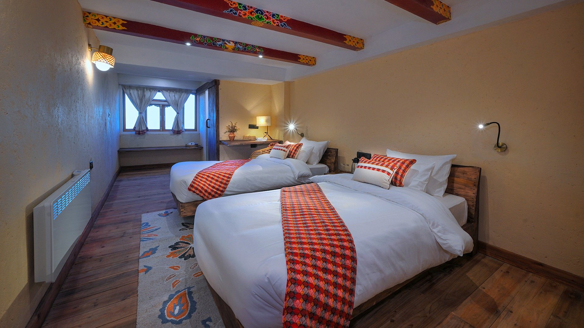 A twin room at Red Panda Outpost with painted beams and red-and-white throws