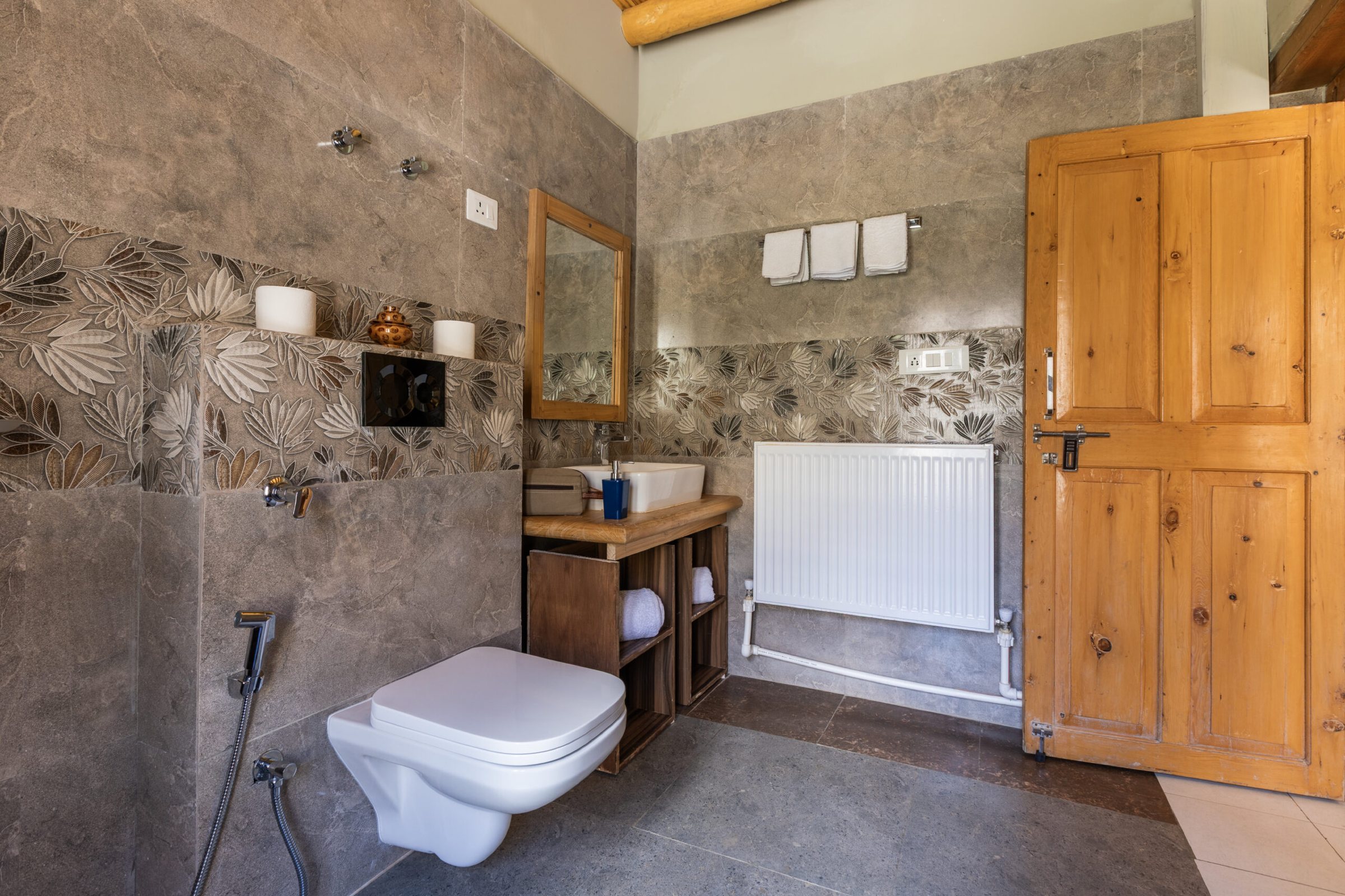 An en suite bathroom at Snow Leopard Lodge with a timber door and a radiator