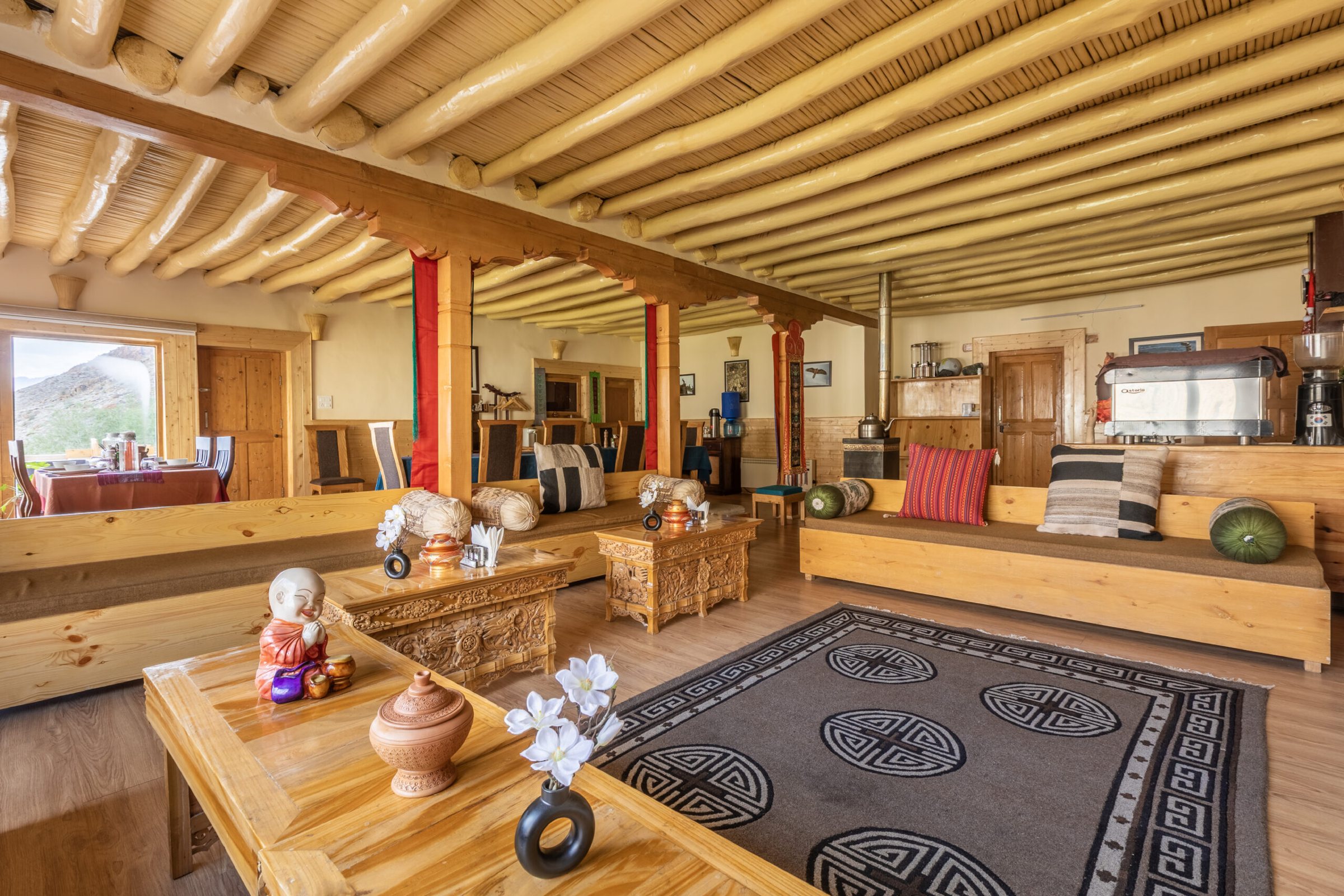 The common room at Snow Leopard Lodge, with low tables and a timber ceiling