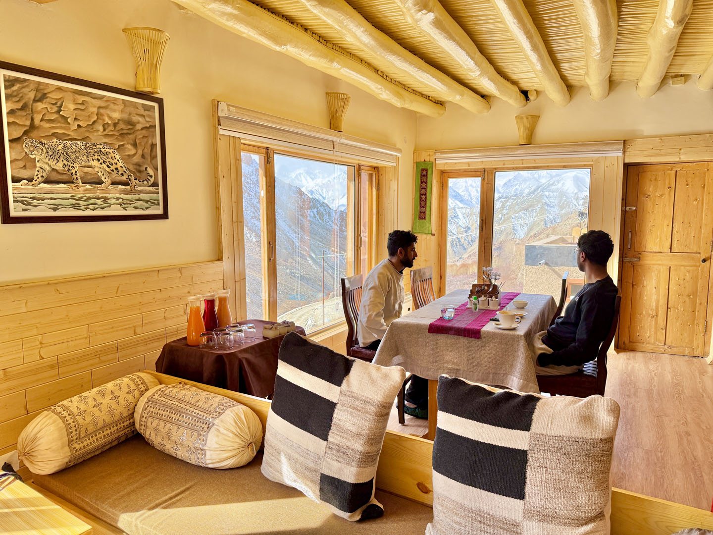 Two guests at a table by the window in a sitting room at Snow Leopard Lodge
