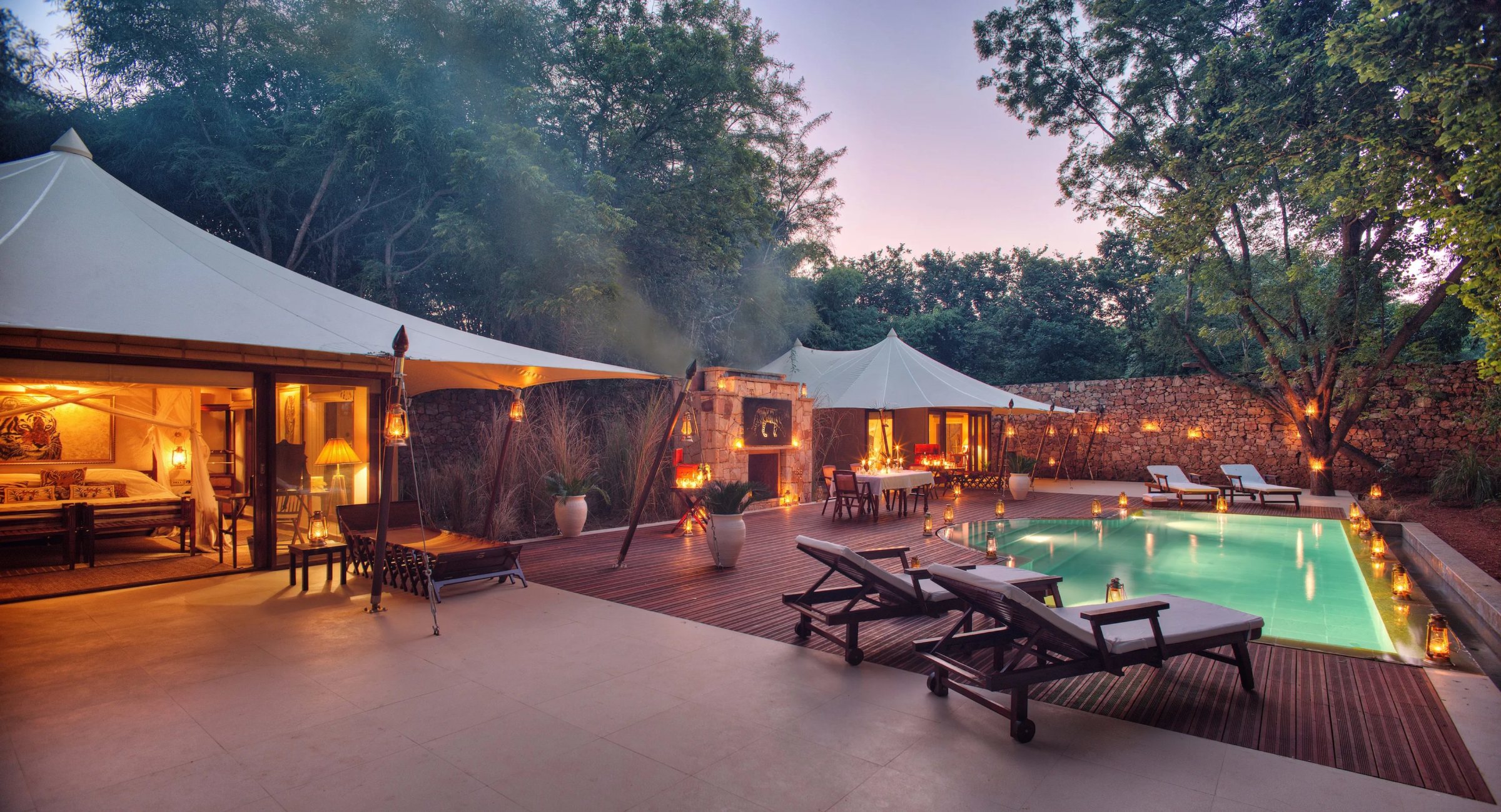 Tents and the pool lit up at dusk at Sujan Jawai
