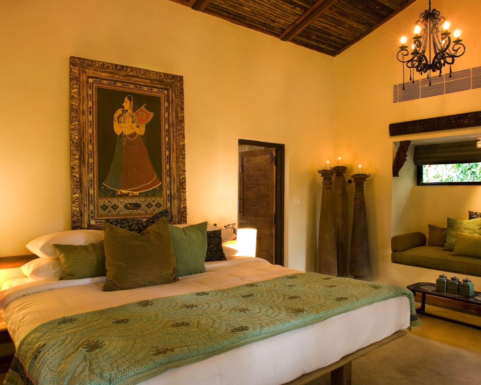 A bedroom at Baghvan, Pench, with a painted textile above the bed