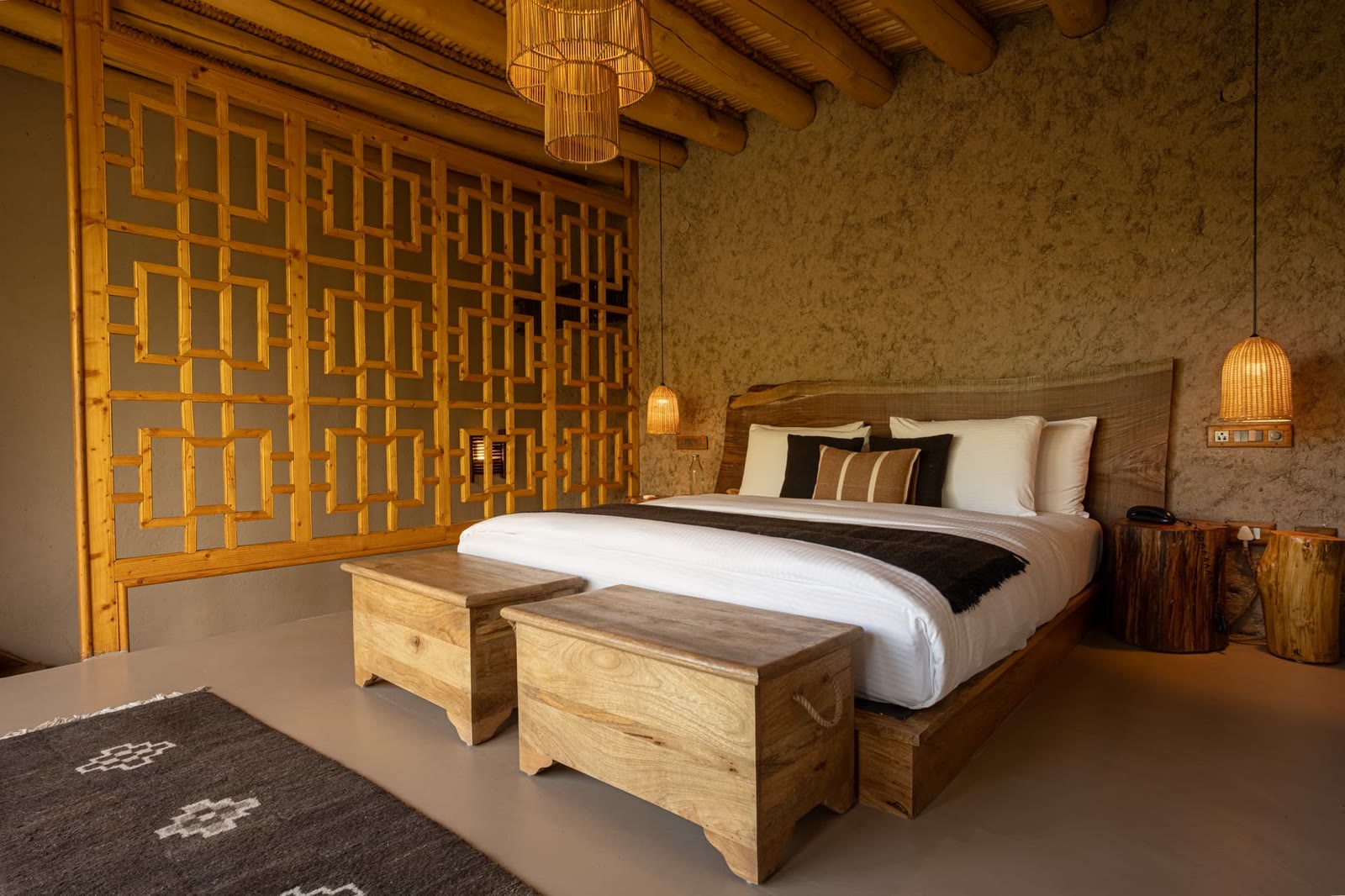 Room at Dolkhar Ladakh, with a carved timber screen, wooden chests and a Ladakhi rug