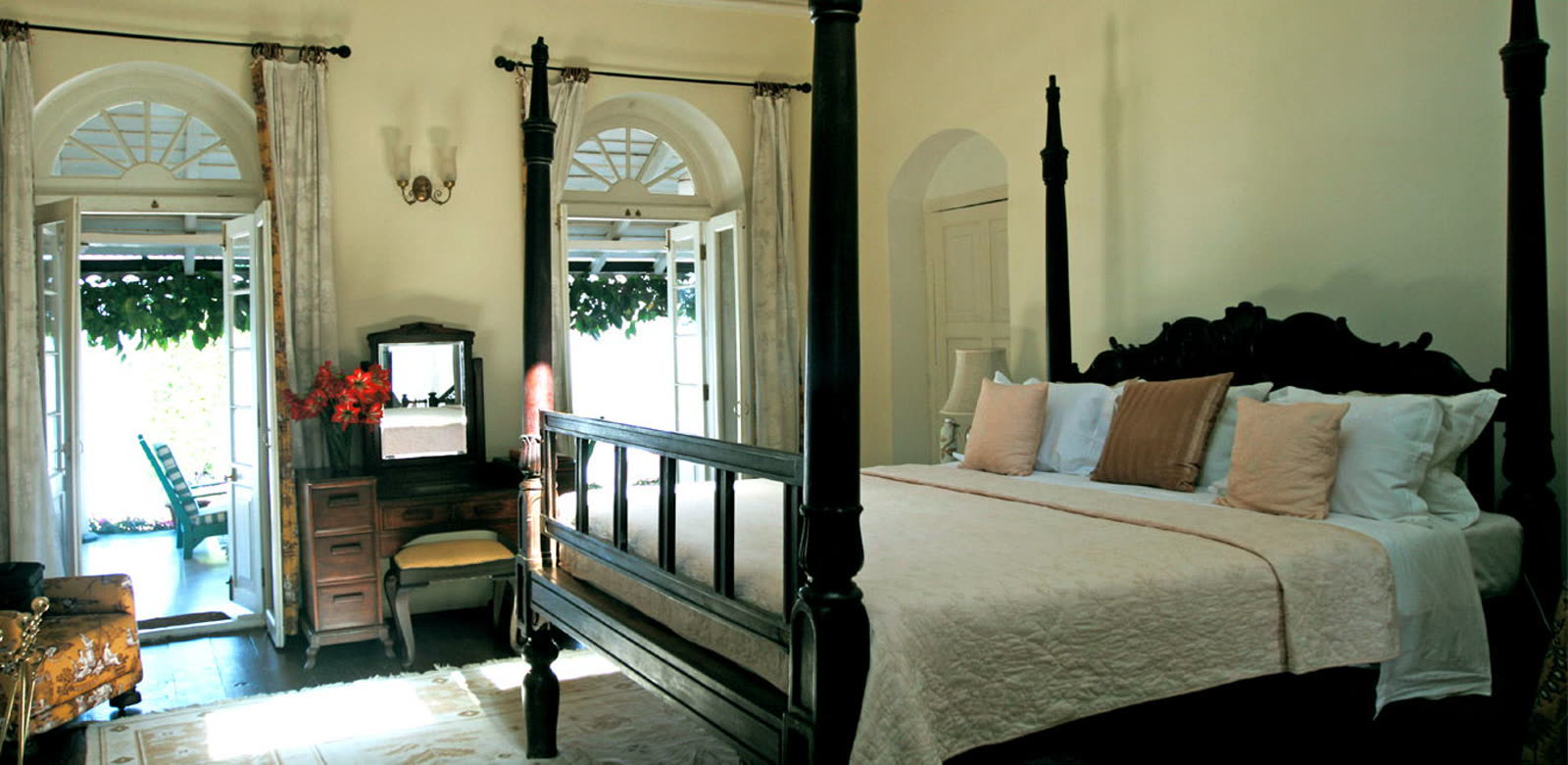 A four-poster bedroom opening onto a veranda at Glenburn Tea Estate