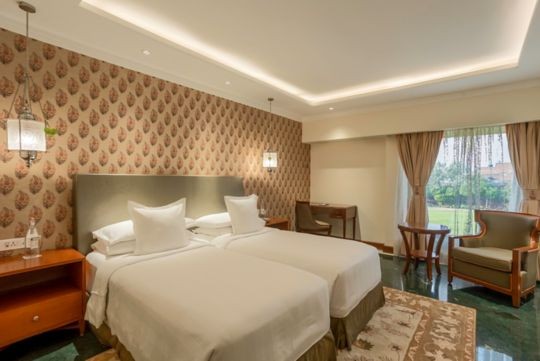 A twin bedroom at ITC Mughal, Agra, looking out onto the gardens