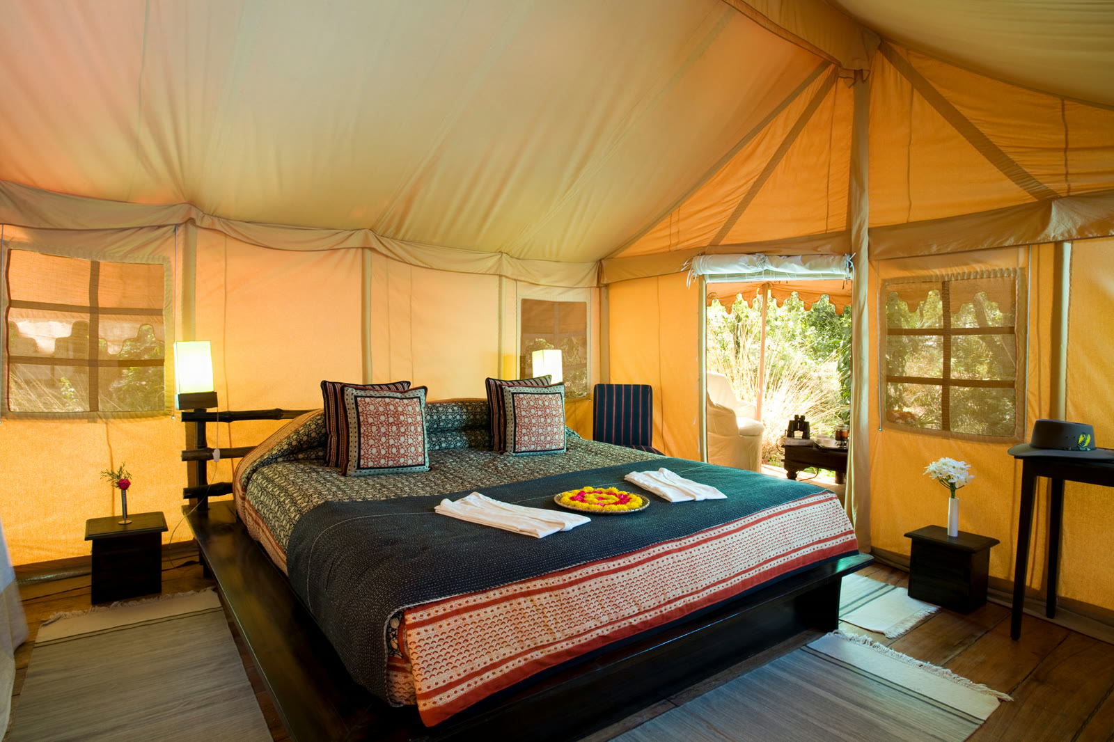 Luxury tent at Khem Villas, with a block-printed bedspread and a door onto the bush
