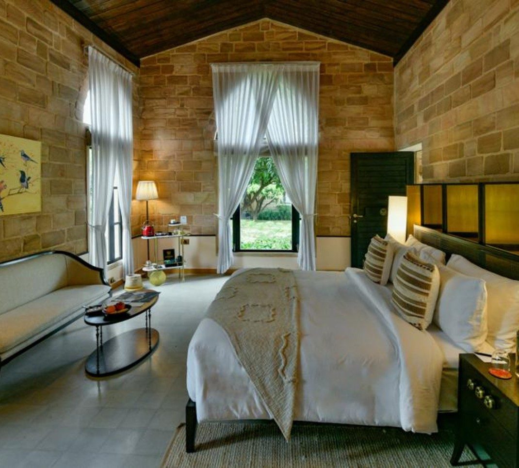 Stone-walled bedroom looking onto the orchard at The Postcard Gir