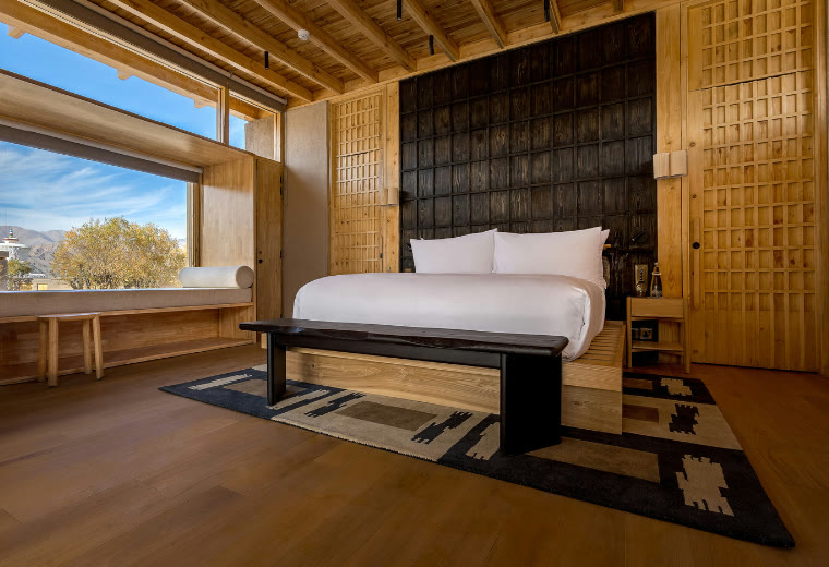 Bedroom of a Willow Suite at The Postcard Willow Suites, with a window onto the mountains of Leh