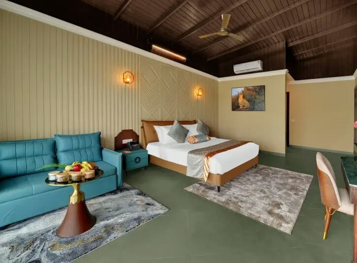 Room at Debu's The Fern Resort & Spa, with a teal sofa, a king bed and a wildlife painting