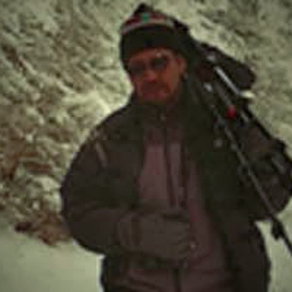 Chitta carrying a tripod through the snow