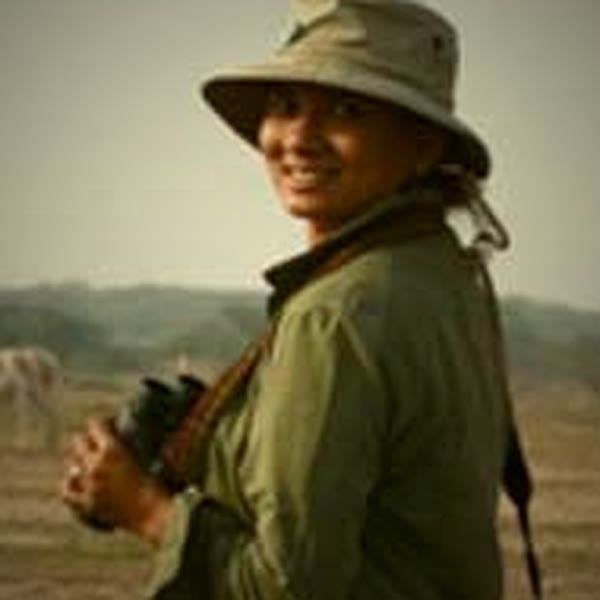Payal Mehta with binoculars on open grassland