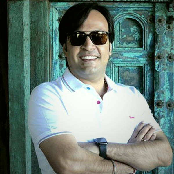 Rohit Gehlot standing before a carved turquoise door